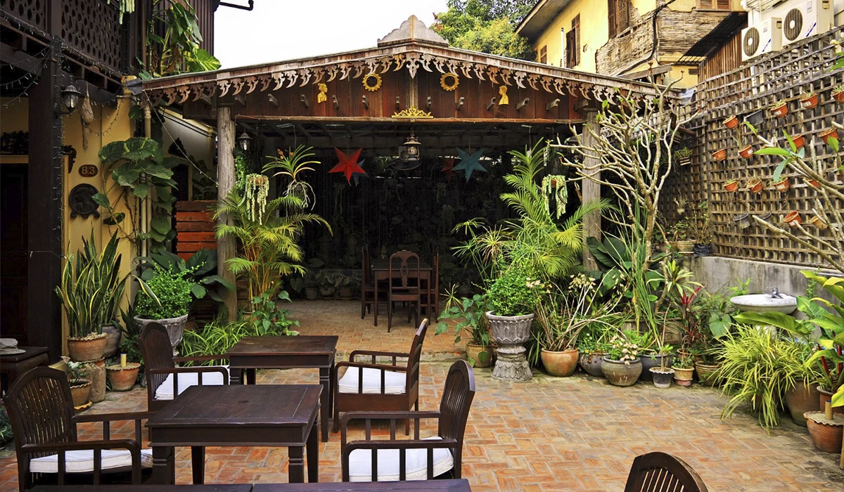 terraza con mesas, plantas y tejado de madera