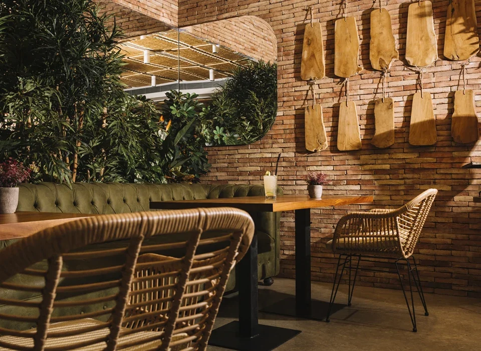 mesa, espejo, pared de ladrillo y plantas en local comercial