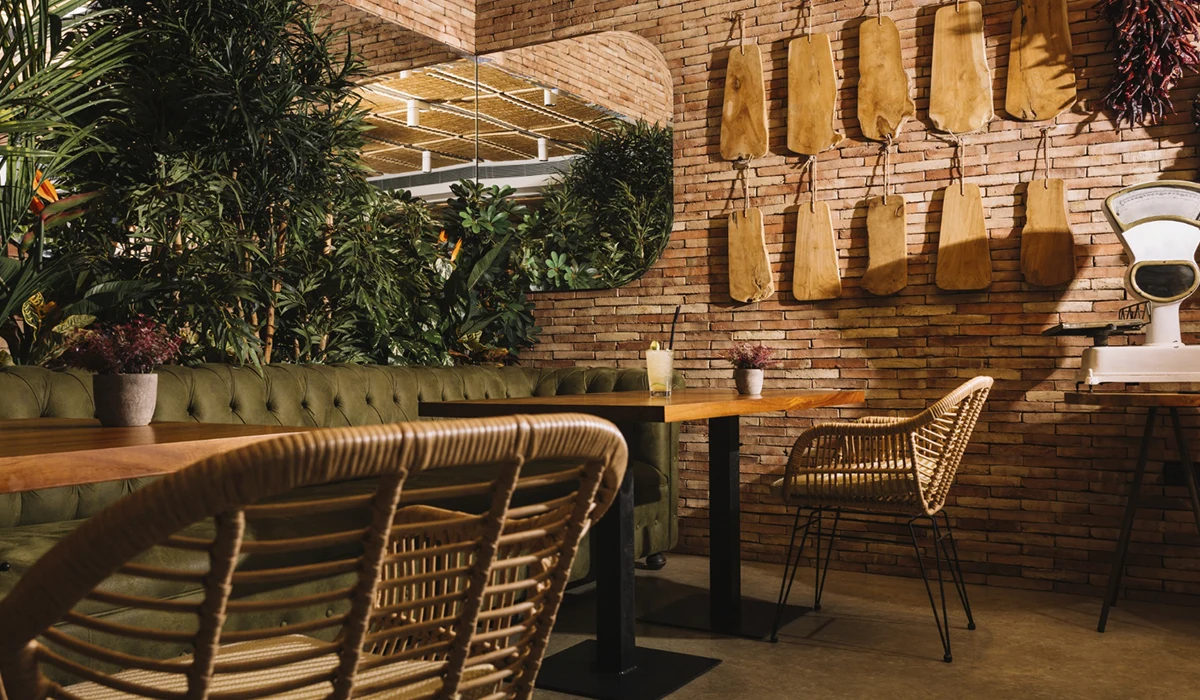 mesa, espejo, pared de ladrillo y plantas en local comercial